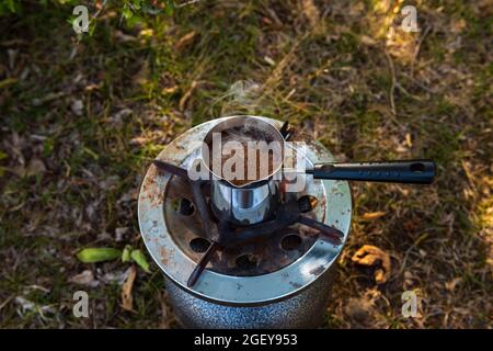 Brewing coffee in cezve on picnic Stock Photo