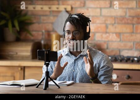 Engaged online coach giving virtual training, recording lecture on smartphone Stock Photo