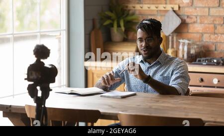 Happy Afro American blogger guy taking video on dslr camera Stock Photo