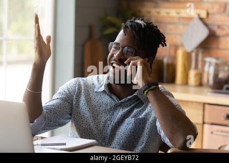 Happy joyful millennial African remote employee working from home Stock Photo