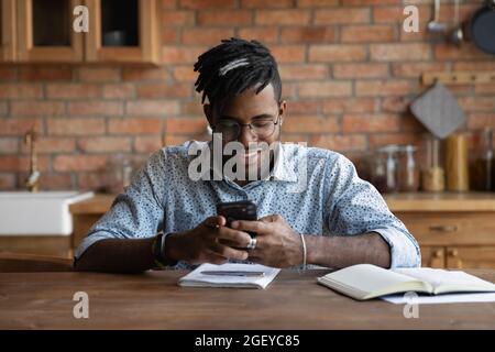 Happy Afro American guy chatting online, checking messages Stock Photo