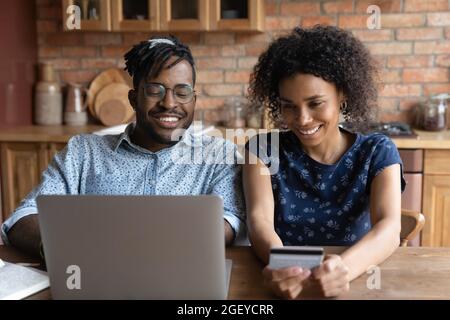 Happy millennial African couple shopping on internet together Stock Photo