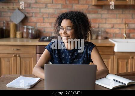 Happy Afro American distance professional in glasses working at laptop Stock Photo