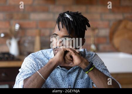 Thoughtful millennial African American man looking at window away Stock Photo