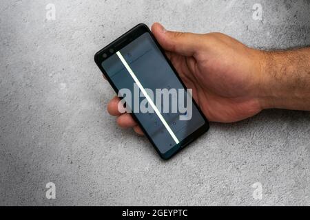 08.15.2021 Moscow, Russian Federation. broken touch screen phone. a man's hand holds a damaged smartphone Stock Photo