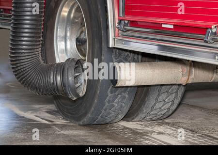 Fire truck exhaust tailpipe with diesel fume extractor hose system. Concept of emission control, firefighter health and safety in firehouse Stock Photo