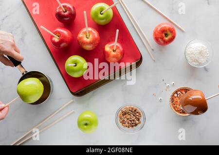 Top down view of apples being prepared to make Halloween caramel apples. Stock Photo