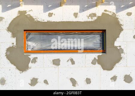 plastering work on the foam-insulated facade of a new private house. Construction and architectureof houses. Stock Photo