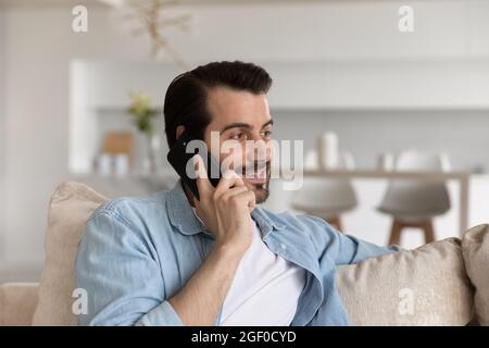 Happy positive man engaged in conversation on cellphone Stock Photo