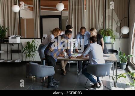 Multiethnic colleagues negotiate brainstorm at team meeting Stock Photo
