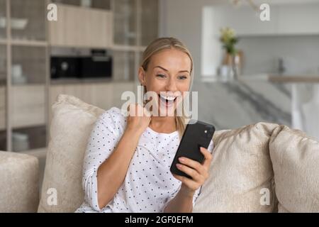 Happy excited smartphone user shouting for joy, getting good news Stock Photo