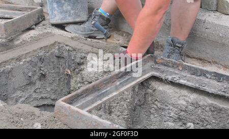 Worker making base for sewer grill. Bulding worker concept Stock Photo