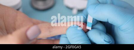 Blood glucose test is taken from patient Stock Photo