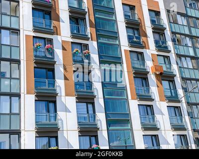 modern apartment building facade decorated with colorful flowers in flowerpots Stock Photo