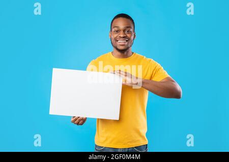 Black Man Showing Poster With Space For Text, Blue Background Stock Photo
