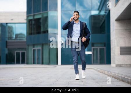 Young middle-eastern entrepreneur going home, talking on phone Stock Photo