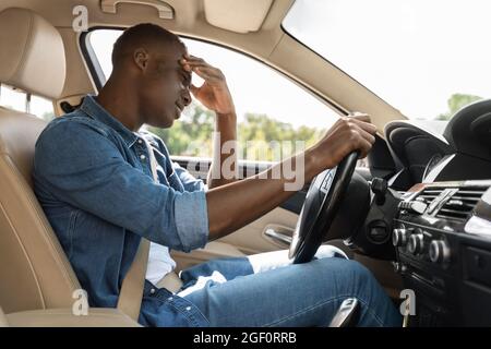 Stressed african american guy stuck in car traffic Stock Photo