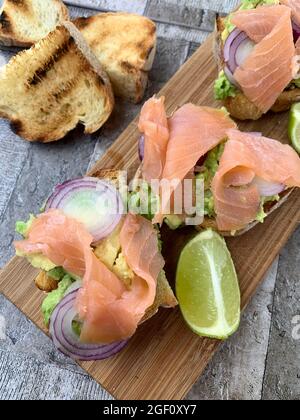 Avocado toast with smoked salmon and red onion. Directly above. Stock Photo