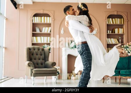 Happy wedding couple, attractive bride and groom hug each other, the groom hugs and holds the bride in his arms and circles her, Happy wedding day, th Stock Photo