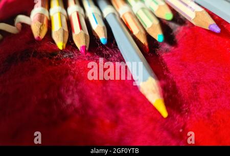Selective focus close up at color pens lying on a red felt surface Stock Photo