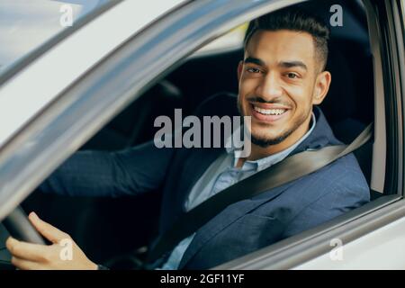 Portrait of smiling middle-eastern businessman driving car Stock Photo