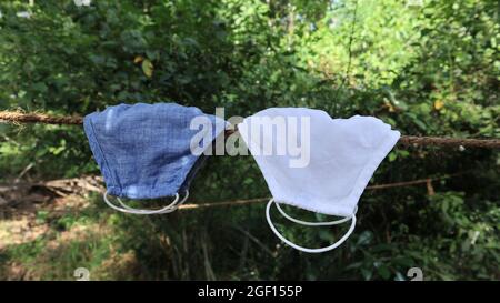 Close up of two cloth face mask hung on a rope to dry after the wash Stock Photo