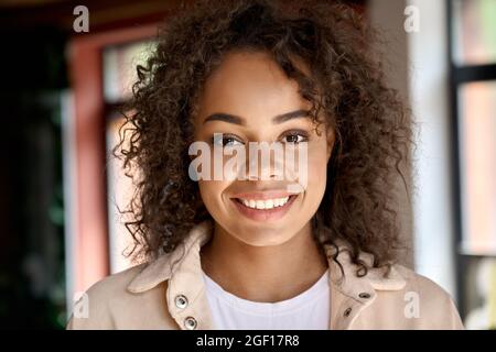 Headshot portrait of young African American woman looking at camera indoors. Stock Photo