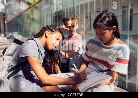 Schoolgirls sitting on floor in classroom Stock Photo - Alamy