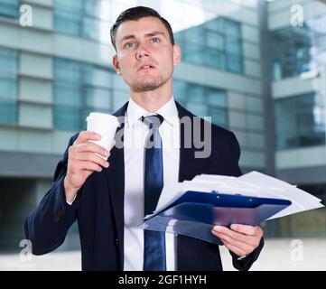 Financial director is examining documents and drinking coffee Stock Photo