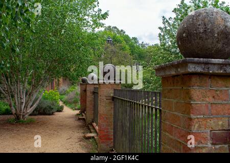 An Iron and Brick fence at The Hill Garden and Pergola, A Georgian arbour and terrace in the Hill Garden with views across Hampstead Heath, London, UK Stock Photo