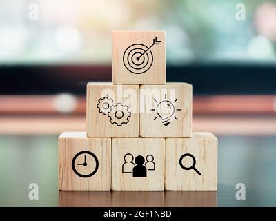 Modern business icons on wooden cube blocks, pyramid steps on desk. Leadership, key success, business strategy and Action plan concept. Stock Photo