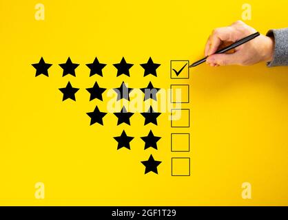 Hand putting a check on the 5 star rating. Survey Concept Stock Photo