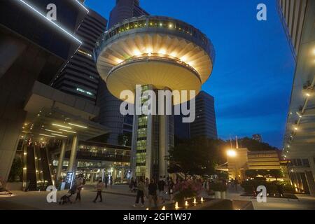 The circular shaped OUE Tower in the CBD financial district of Singapore in evening light Stock Photo
