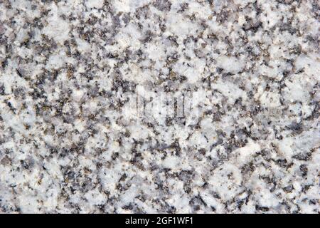 Gray granite with yellow-white inclusions. Background granite texture, top view. Stock Photo