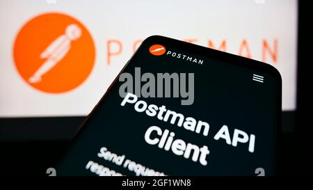 Mobile phone with webpage of American collaboration platform company Postman Inc. on screen in front of logo. Focus on top-left of phone display. Stock Photo