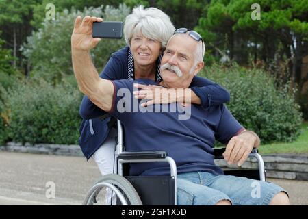 senior couple in wheelchair taking selfies Stock Photo