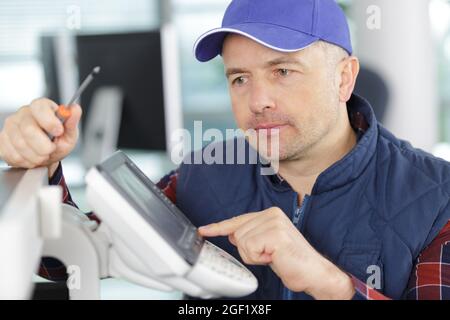 hardware repairman repairing broken printer Stock Photo