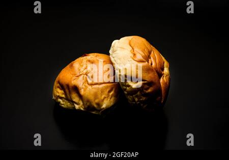 Two delicious burger buns on a dark background Stock Photo