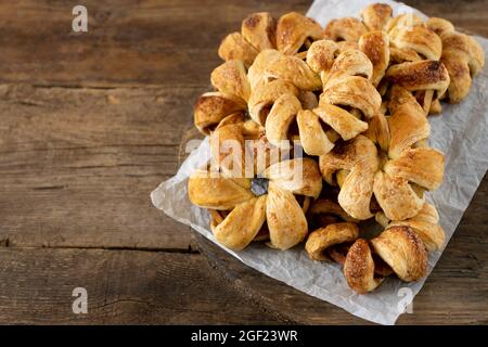 Apple rings in dough. Sweet homemade cakes. Puff pastry pies with apple filling. Simple pie on a wooden background. Copy space. Food for dessert Stock Photo