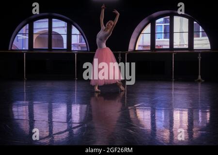 Young ballet dancer dressed in a tutu practices her dance in a rehearsal hall in Saint Petersburg in preparation for a performance. Stock Photo