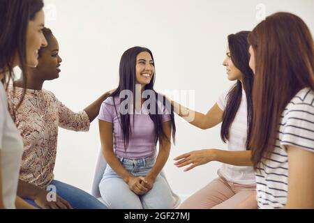 Diverse group of happy supportive beautiful young ladies talking to their friend Stock Photo