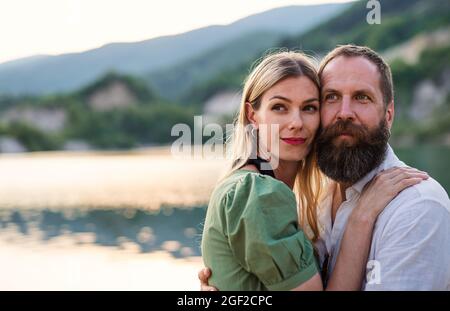 Happy mature couple in love hugging in nature, looking at camera. Stock Photo