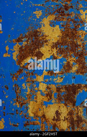 flat texture of rusted steel sheet with two peeled off layers of paint - yellow and blue Stock Photo