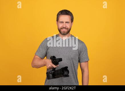 cheerful bearded man videographer making movie for vlog with camcorder, video Stock Photo