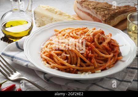 Amatriciana pasta. Bucatini amatriciana, Italian recipe from Amatrice, with peeled tomatoes, pecorino cheese, bacon and extra virgin olive oil. Stock Photo