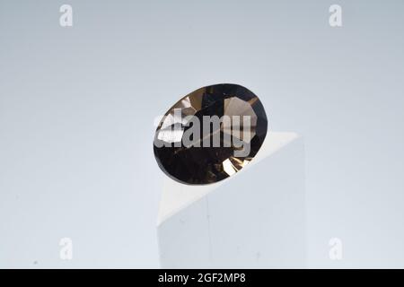 Natural smoky quartz stone on a stand on a white background Stock Photo