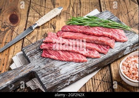 Premium Rare Slices of Wagyu A5 beef with high marbled texture. wooden background. Top view Stock Photo