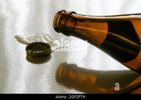 empty beer bottle and crown cap lying on a table, Austria Stock Photo