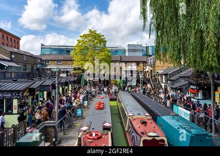 LONDON CAMDEN LOCK CAMDEN TOWN FAST FOOD SHOPS AND CROWDS SURROUND NARROWBOATS ON THE CANAL IN SUMMER Stock Photo