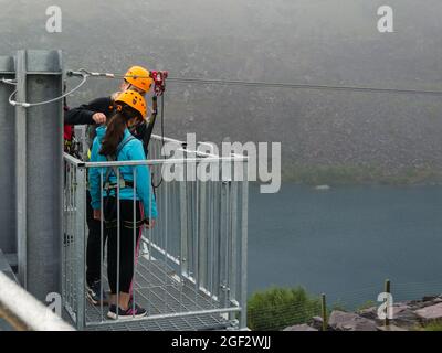 Girl being safety checked before going down the Quarry Flyer at Zip World Adventure Bethesda Gwynedd North Wales UK Stock Photo